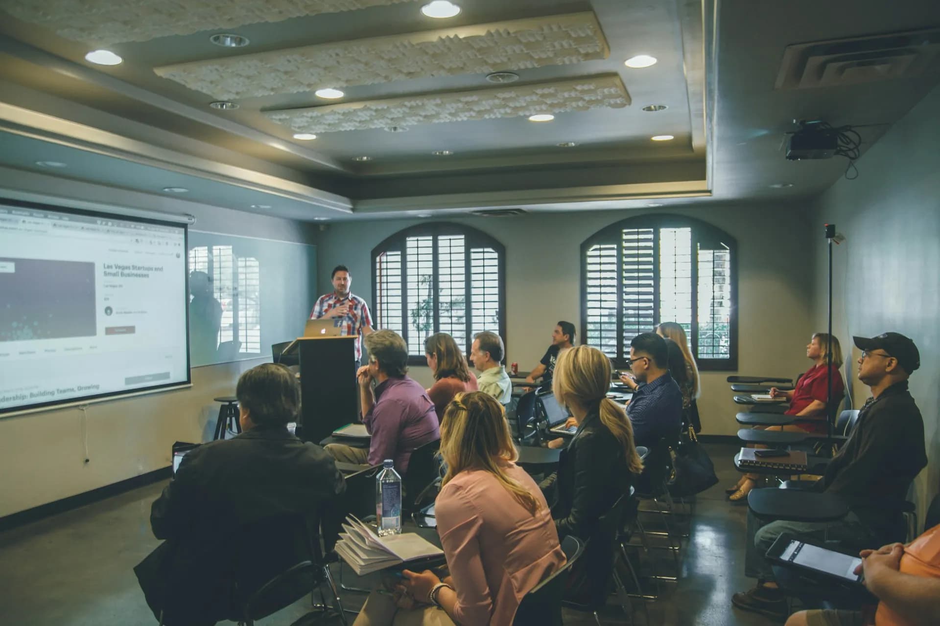 a group of-people in a room with a projector screen